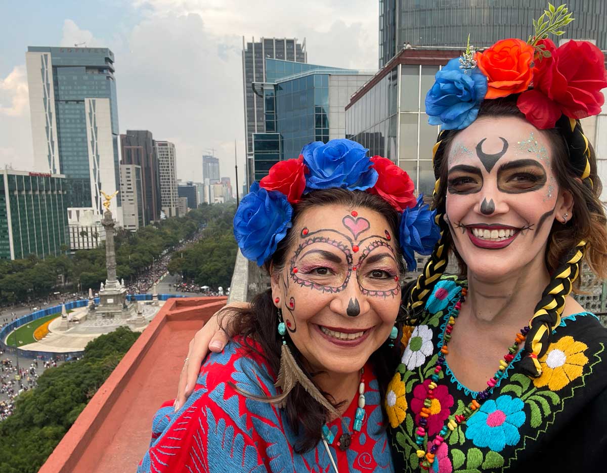 Two women dressed as skeletons with flower headbands
